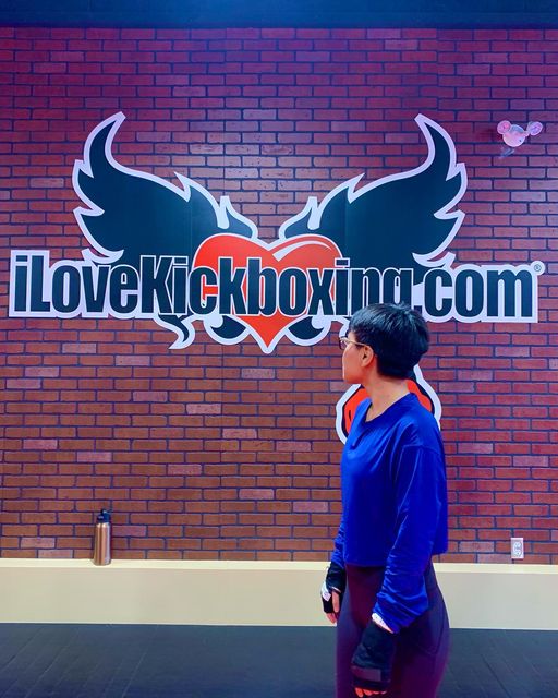 dyana castillo posing in front of ilovekickboxing mural